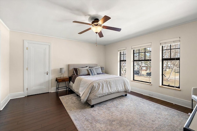 bedroom featuring a ceiling fan, dark wood-style floors, baseboards, and ornamental molding