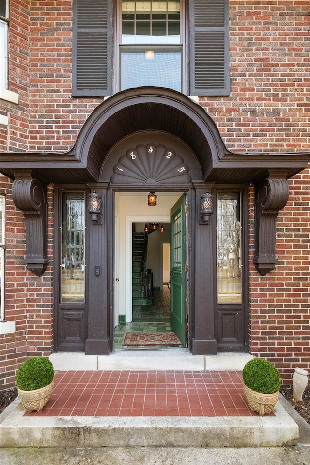 view of exterior entry with brick siding