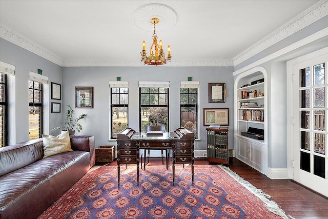 office area with built in shelves, baseboards, a chandelier, ornamental molding, and wood finished floors