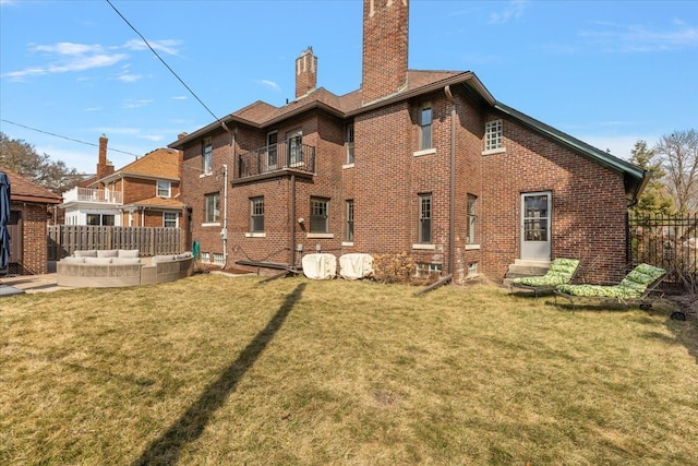 back of property featuring a lawn, an outdoor living space, fence, brick siding, and a chimney