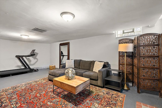 living area featuring visible vents and finished concrete floors