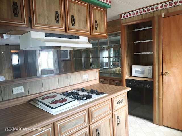 kitchen featuring white appliances, under cabinet range hood, brown cabinets, and light countertops