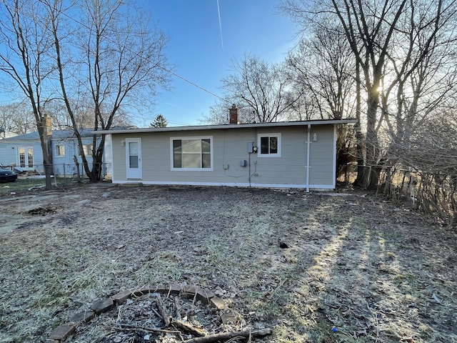 rear view of house featuring fence and a chimney