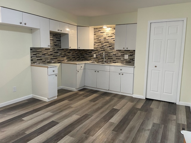 kitchen featuring dark wood-style floors, decorative backsplash, white cabinetry, and a sink