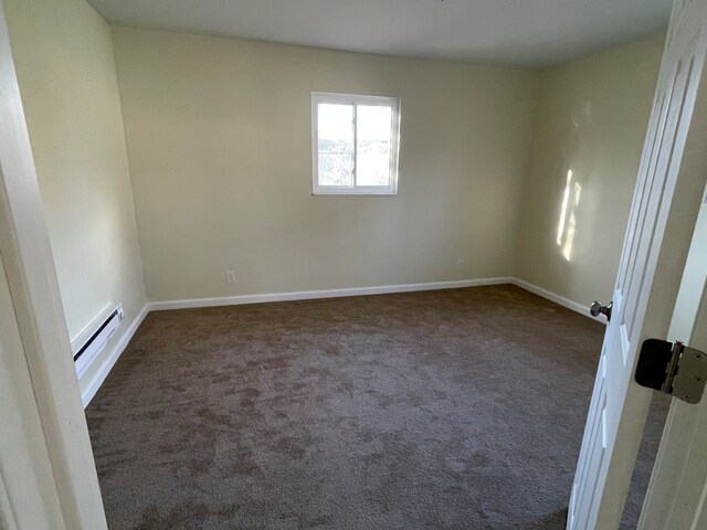 unfurnished room with dark colored carpet, baseboards, and baseboard heating