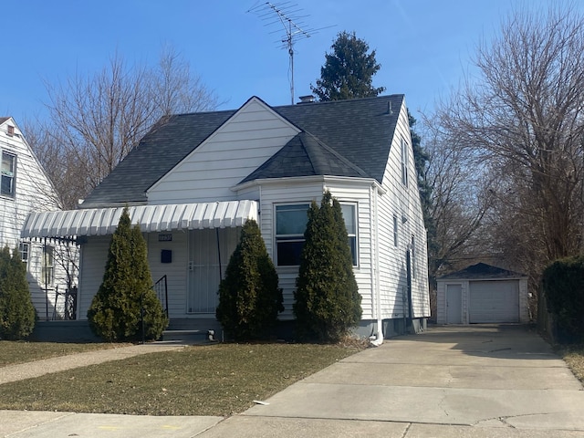 view of front of property featuring driveway, roof with shingles, covered porch, an outdoor structure, and a detached garage