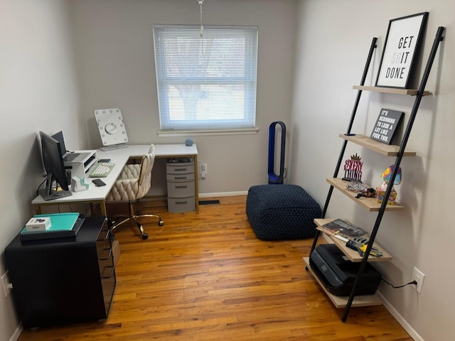 office featuring baseboards, visible vents, and light wood-style floors