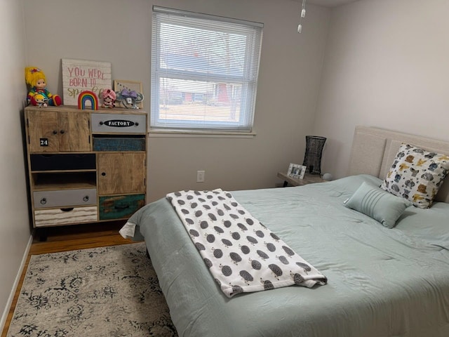 bedroom with baseboards and wood finished floors