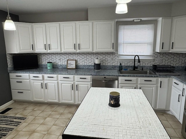 kitchen featuring tasteful backsplash, dishwasher, white cabinetry, pendant lighting, and a sink