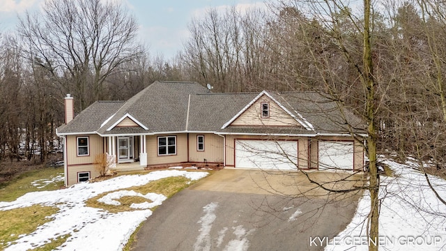 view of front of property with driveway, a garage, and a chimney