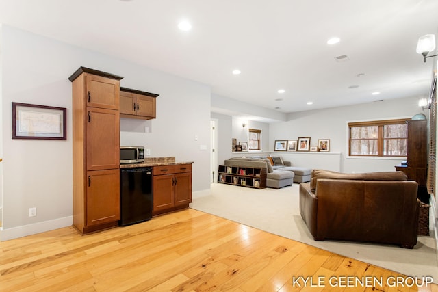 living room featuring baseboards, light wood-style flooring, and recessed lighting