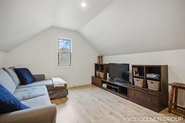 living area featuring vaulted ceiling, wood finished floors, and baseboards