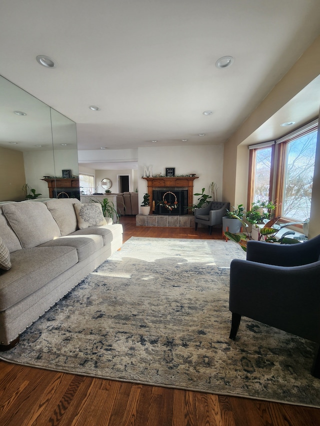 living area featuring a tile fireplace, recessed lighting, and wood finished floors