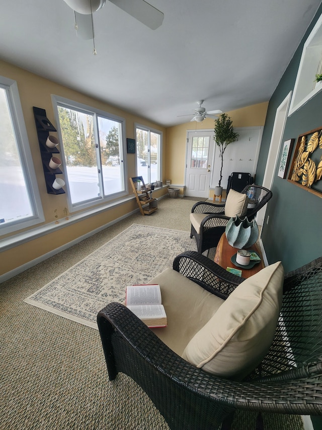 living room with carpet floors, baseboards, and a ceiling fan