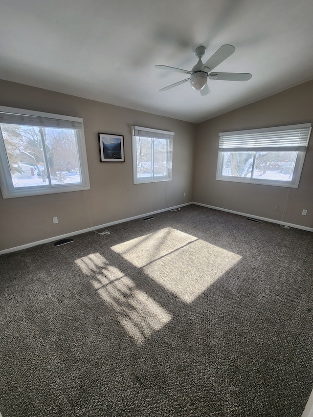 empty room featuring carpet, lofted ceiling, visible vents, ceiling fan, and baseboards