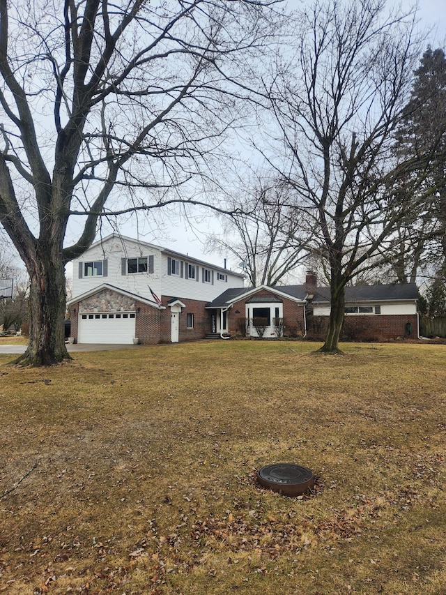 traditional-style home featuring an attached garage, a front yard, and brick siding