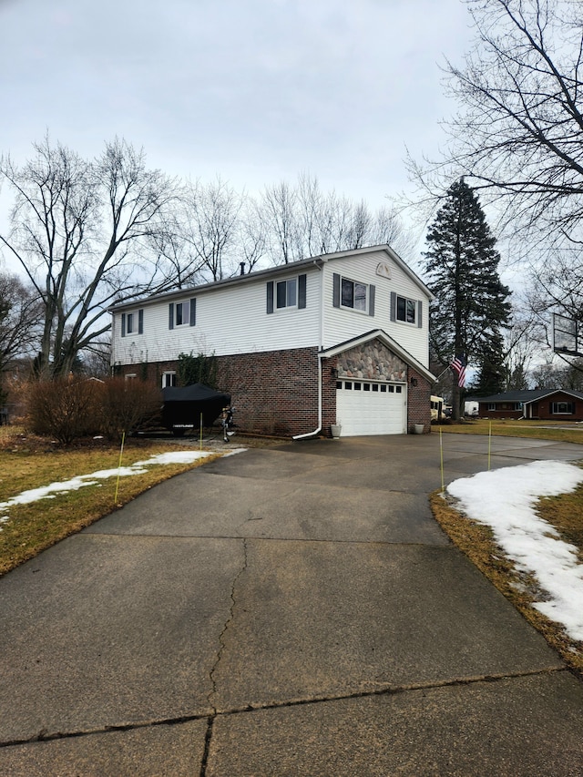 view of front of house featuring driveway, an attached garage, and brick siding