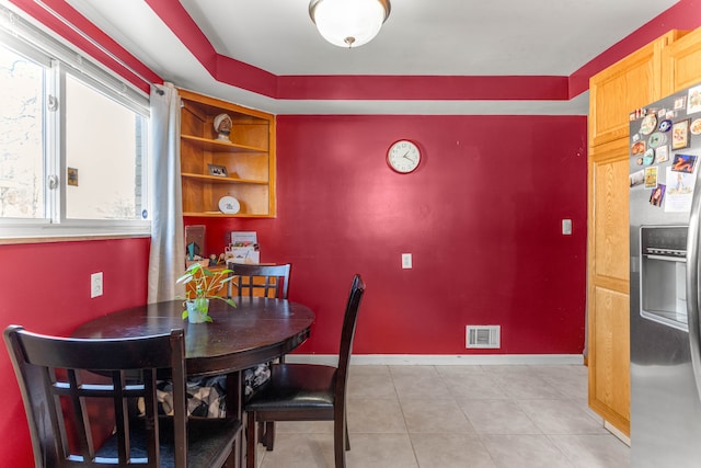 dining space with light tile patterned floors, baseboards, and visible vents