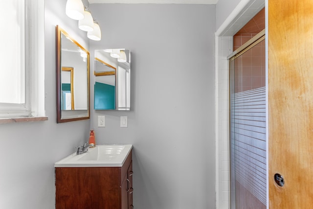 full bath with tiled shower and vanity