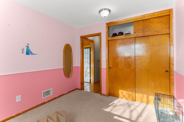 unfurnished bedroom with a closet, carpet flooring, visible vents, and baseboards