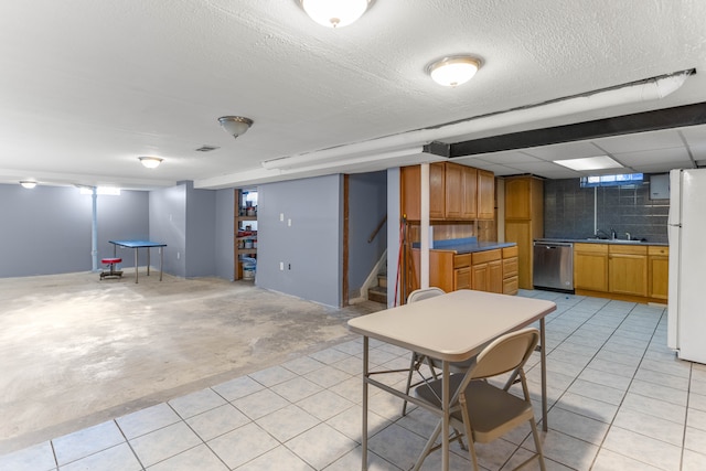 below grade area with a textured ceiling, stairway, a sink, and freestanding refrigerator