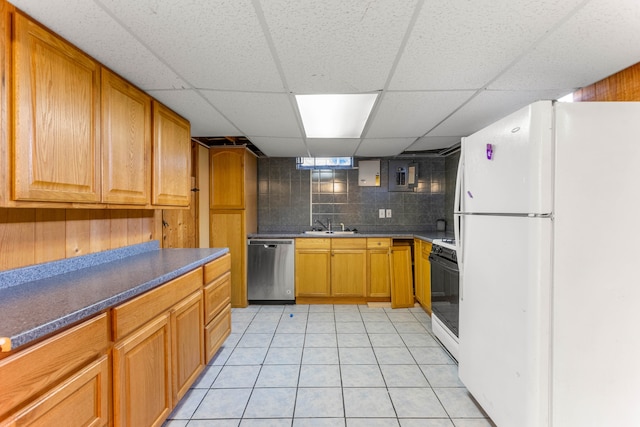 kitchen featuring light tile patterned floors, range with gas stovetop, freestanding refrigerator, stainless steel dishwasher, and a sink