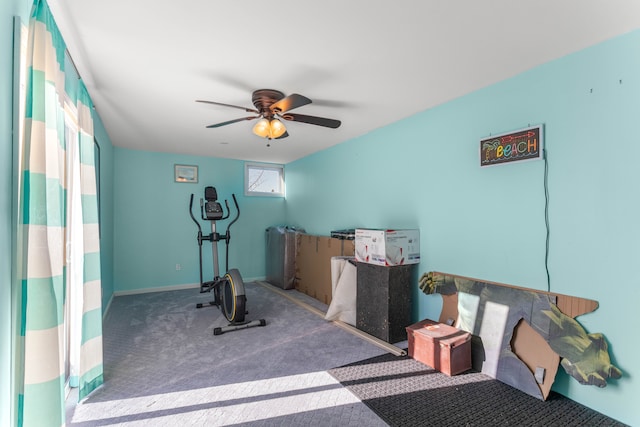 exercise area with baseboards, a ceiling fan, and carpet flooring