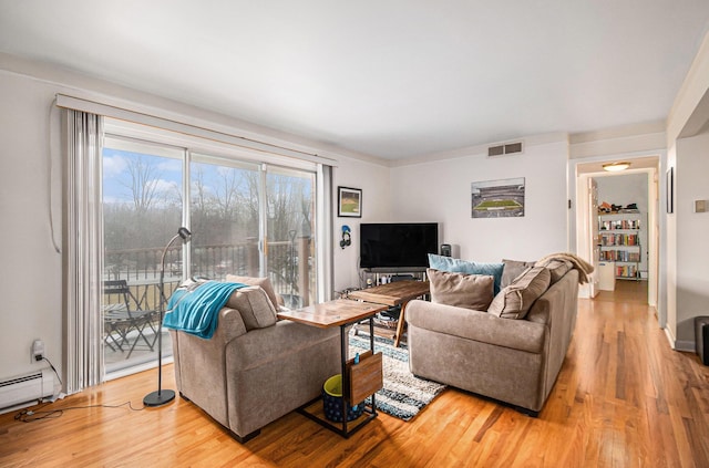 living area featuring a baseboard heating unit, wood finished floors, and visible vents