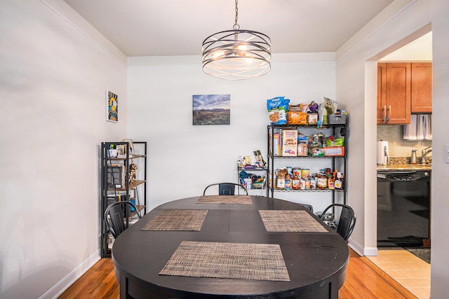 dining area with light wood finished floors, baseboards, and a chandelier