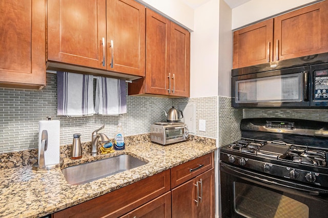 kitchen with black appliances, tasteful backsplash, and a sink