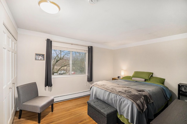 bedroom with baseboard heating and light wood-type flooring