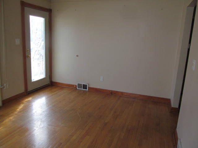 unfurnished room featuring light wood-style floors, baseboards, and visible vents