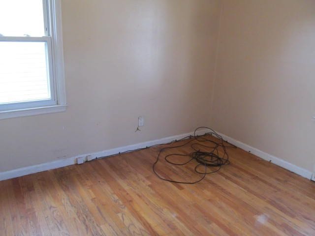 unfurnished room featuring baseboards and wood finished floors