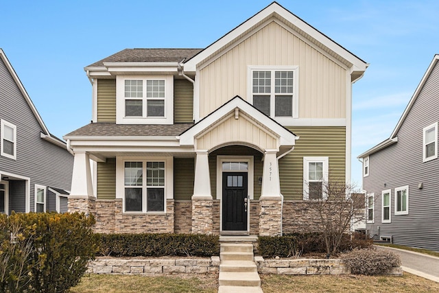 craftsman house featuring covered porch, stone siding, and a shingled roof