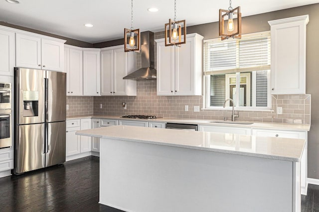 kitchen with wall chimney exhaust hood, dark wood-style flooring, stainless steel appliances, white cabinetry, and a sink