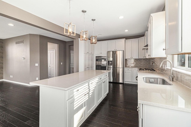 kitchen with stainless steel appliances, visible vents, a sink, and tasteful backsplash