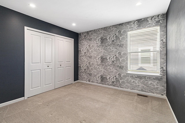 unfurnished bedroom with baseboards, visible vents, carpet flooring, and recessed lighting