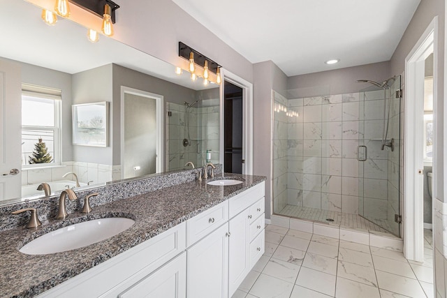 full bathroom with marble finish floor, double vanity, a sink, and a shower stall