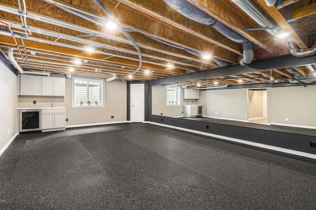 basement with a sink, baseboards, and a dark floor