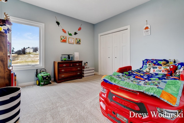 bedroom with a closet, carpet, visible vents, and baseboards