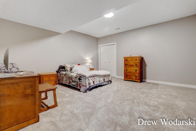 carpeted bedroom with a closet, visible vents, and baseboards