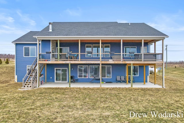 back of property featuring a patio area, a yard, stairway, and roof with shingles