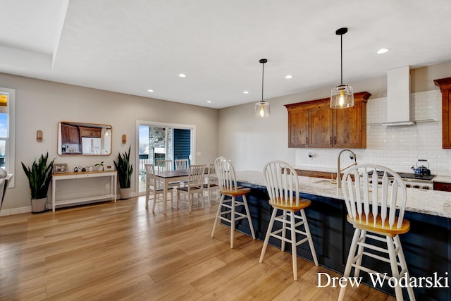 kitchen with light wood-style floors, tasteful backsplash, a breakfast bar, and recessed lighting