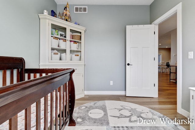 bedroom with light wood-style floors, baseboards, and visible vents