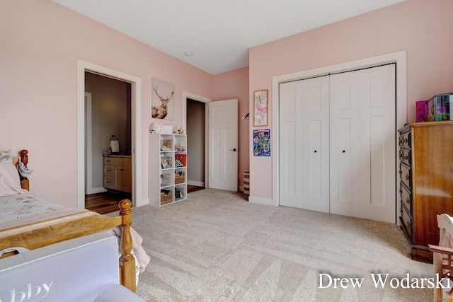 bedroom with carpet, baseboards, a closet, and ensuite bathroom