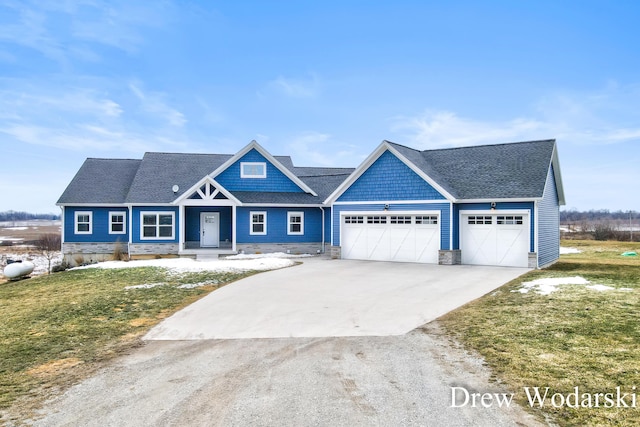 view of front of house with an attached garage, a front yard, concrete driveway, and roof with shingles