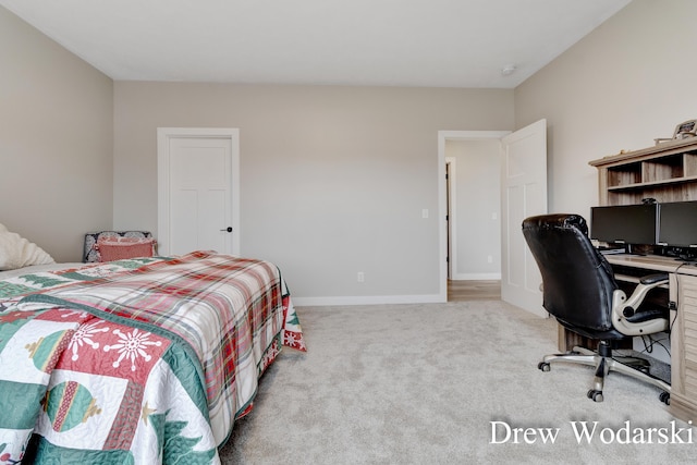 bedroom featuring light colored carpet and baseboards