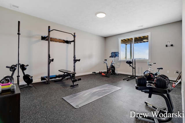 exercise area with baseboards and a textured ceiling