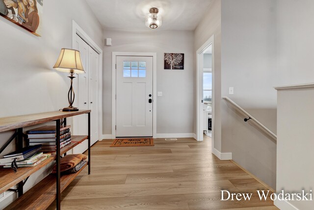 foyer entrance with light wood-type flooring and baseboards