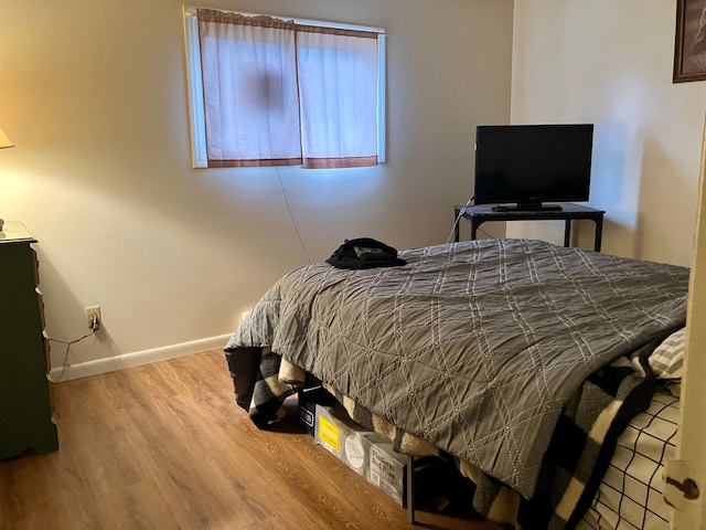 bedroom with baseboards and wood finished floors